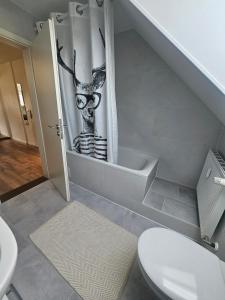 a bathroom with a toilet with a reindeer mural at Talblick Saschwalle in Sasbachwalden +13 photos