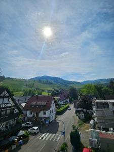 a view of a town with the sun in the sky at Talblick Saschwalle in Sasbachwalden