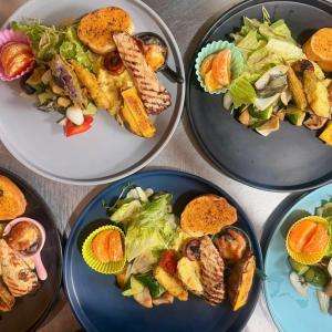 a table with four plates of food and a salad at 厝True Hub旅店 in Nanwan