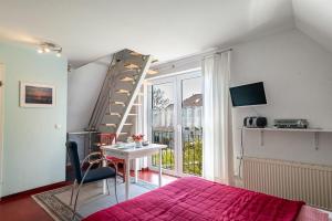a bedroom with a bed and a staircase and a table at Sonne in Diedrichshagen