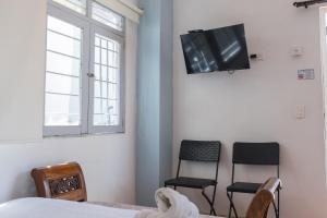 a bedroom with two chairs and a tv on the wall at Casa Crespo in Cartagena de Indias
