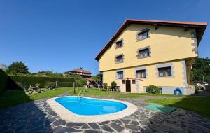 a house with a swimming pool in front of a building at Viviendas Turisticas El Carrascal in La Gandara