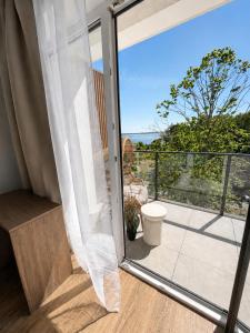 a room with a glass door leading to a balcony at Essentia Apartament 405 in Dziwnów