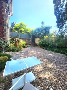 a glass table on the ground in a yard at La Villa Convivium - Chambres privées in Rouen