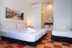 a bedroom with two beds and a mirror at Casa Crespo in Cartagena de Indias +59 photos