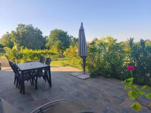 a table and chairs and an umbrella on a patio at Doume et Coco T1 30M2 Vue mer in Taglio-Isolaccio