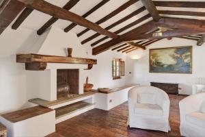 a living room with white furniture and wooden ceilings at La Migliana by Nicola Real Estate in Corsanico-Bargecchia