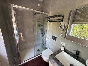 a bathroom with a shower and a toilet and a sink at Happy Hue rooms Malpensa airport in Samarate