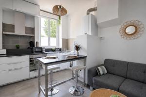 a kitchen and living room with a table and a couch at Chamotte Hyper Centre WIFI Cosy in Bourg-en-Bresse