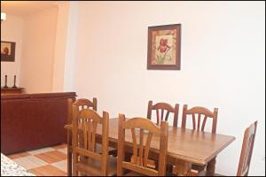 comedor con mesa de madera y sillas en Apartamento San José Conil, en Conil de la Frontera