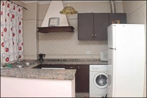 cocina con nevera blanca y lavavajillas en Apartamento San José Conil, en Conil de la Frontera