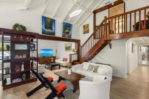 a living room with a white couch and a staircase at La Source Guest House in Orient Bay