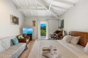 a living room with a large bed and a couch at La Source Guest House in Orient Bay