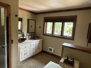 a bathroom with two sinks and a window at Mountain Modern 4 Bedroom Cabin on Hiking Trails in Fairplay +24 photos