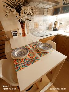 a white table with two plates on it in a kitchen at ALMAREDo in Bisceglie +17 photos