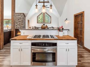 a kitchen with white cabinets and a stove top oven at Mountain Modern 4 Bedroom Cabin on Hiking Trails in Fairplay