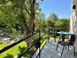 a balcony with a table and chairs and a tree at Casa Cențiu II in Bran