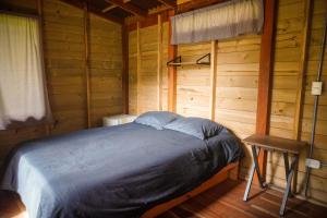 a bedroom with a bed in a wooden cabin at Refugio Munay in Florián +18 photos