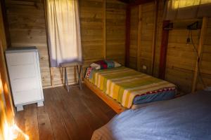 a bedroom with two beds in a wooden cabin at Refugio Munay in Florián