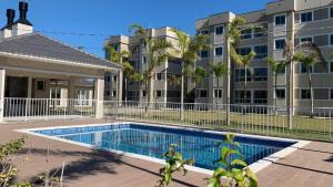 a swimming pool in front of a apartment building at Apartamento Moderno em Floripa - Ideal para Famílias in São José