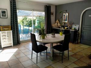 a kitchen with a table and chairs in a room at L'ABREUVOIR chez l'habitant 1 Chambre d'hôtes lit 140 et 1chambre d'hôtes 2 lits 90 in Surgères