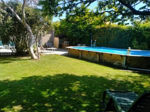 a swimming pool in a yard with a tree at L'ABREUVOIR chez l'habitant 1 Chambre d'hôtes lit 140 et 1chambre d'hôtes 2 lits 90 in Surgères