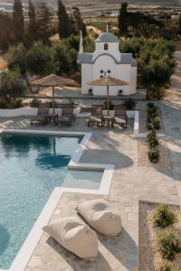 a pool with benches and umbrellas next to a building at Paranthos Island Living in Chrissi Akti