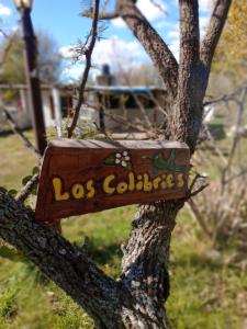 a wooden sign on a tree in a yard at Los Colibríes de Potrero in Potrero de Garay +12 photos