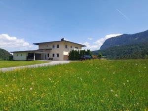 a house in the middle of a field of grass at Villa Werlberger in Thiersee