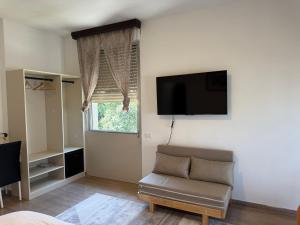 a living room with a chair and a flat screen tv at Happy Hue rooms Malpensa airport in Samarate