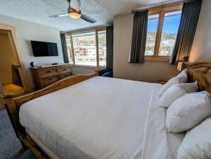 a bedroom with a large white bed and a television at Argentine 1516 by SummitCove Lodging in Colorado in Keystone +51 photos