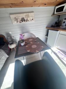 a small room with a table and a refrigerator at Le Petit Farfadet in Flangebouche