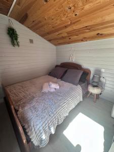a bed in a room with a wooden ceiling at Le Petit Farfadet in Flangebouche