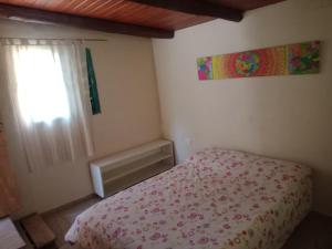 a small bedroom with a bed and a window at Los Colibríes de Potrero in Potrero de Garay