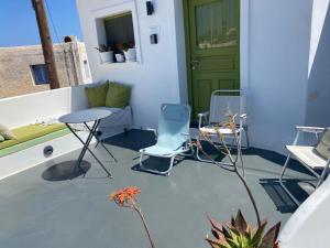 a patio with two chairs and a green door at Finikas Cave House in Foinikiá