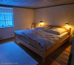 a bedroom with a large bed with two pillows at Typisches Schwedisches Haus in Eriksmåla