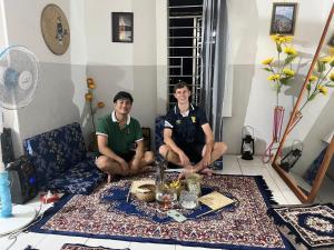 two men sitting in a living room with a table at Backpackers Hub in Dimapur
