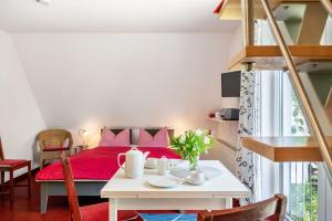 a room with a bed and a table with a red blanket at Ostsee in Diedrichshagen +16 photos