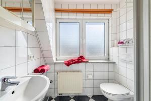 a bathroom with a toilet and a sink and a window at Ostsee in Diedrichshagen