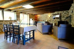a dining room with a white table and chairs at Ferme de Lamourio in Saint-Cernin
