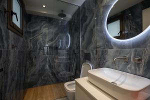 a bathroom with a sink and a mirror at Santerra Suites in Rhodes Town +70 photos