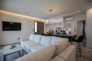 a living room with a white couch and a kitchen at Santerra Suites in Rhodes Town