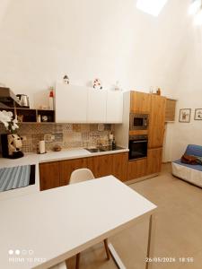 a kitchen with white cabinets and a white table at ALMAREDo in Bisceglie