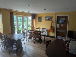 a dining room with tables and chairs and a guitar at Half Moon Inn in Llanthony