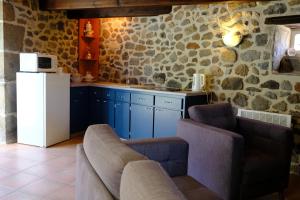 a kitchen with blue cabinets and a white refrigerator at Ferme de Lamourio in Saint-Cernin +8 photos