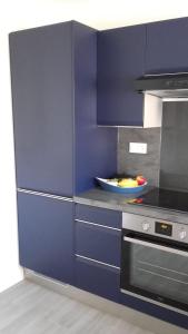 a kitchen with blue cabinets and a stove at House close to the town center and the beach in Quiberon