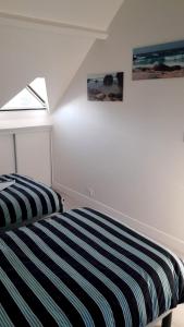 a bedroom with a bed and two pictures on the wall at House close to the town center and the beach in Quiberon +20 photos