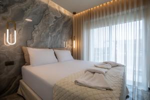 a bedroom with a large bed and a large window at Santerra Suites in Rhodes Town