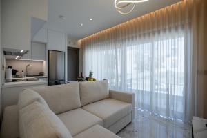 a living room with a couch and a large window at Santerra Suites in Rhodes Town