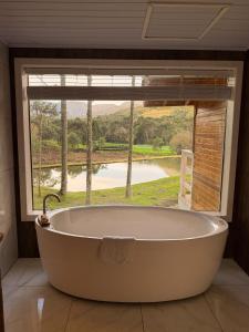 a bath tub in a room with a large window at Rancho Canto da Lua in Urubici +97 photos